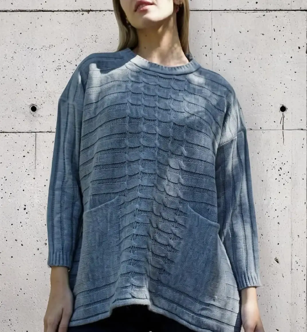 Sweater largo de mujer, tejido con diseño de trenzas y bolsillos delanteros. Ideal para un look casual y abrigado.