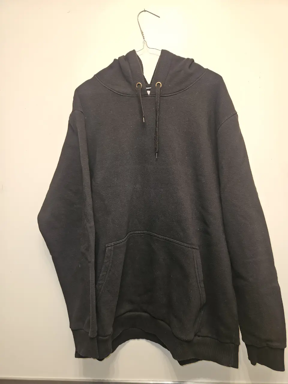 Buzo canguro negro, ideal para un look casual y cómodo. Confeccionado en un tejido suave y abrigado, perfecto para el invierno. Posee capucha y bolsillo frontal tipo canguro.