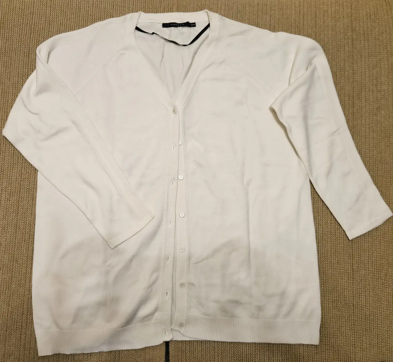 Cardigan blanco de hilo, con botones y cuello en V. Ideal para un look casual y versátil.