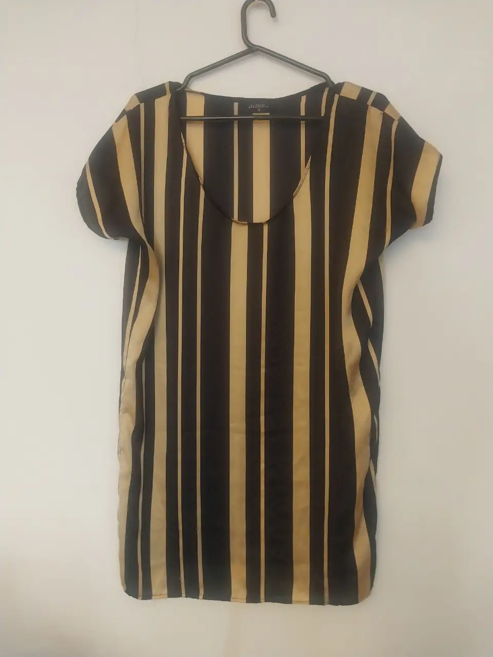 Vestido de mujer con estampado a rayas verticales en negro y dorado. Cuello redondo y mangas cortas. Ideal para un look casual y elegante.