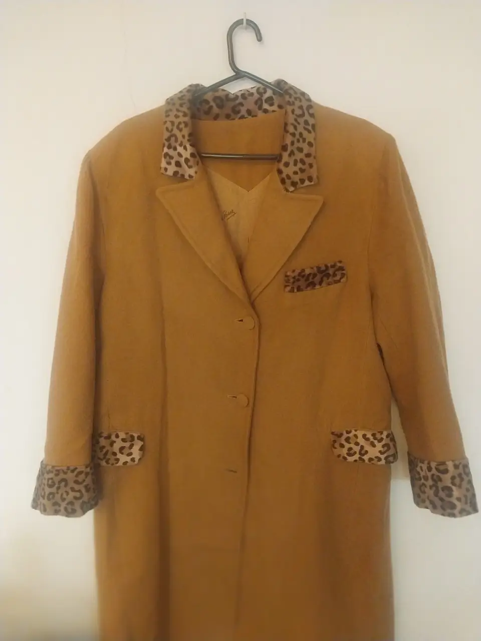 Tapadoo largo de color marrón /camel con detalles de estampado de animal print en cuello, bolsillos y puños. Ideal para un look elegante y sofisticado. 