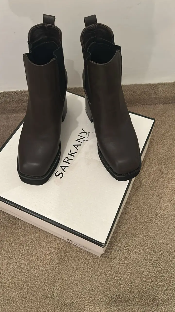 Botinetas de cuero marrón oscuro con taco cuadrado y plataforma. Ideales para un look moderno y sofisticado. Marca Sarkany.