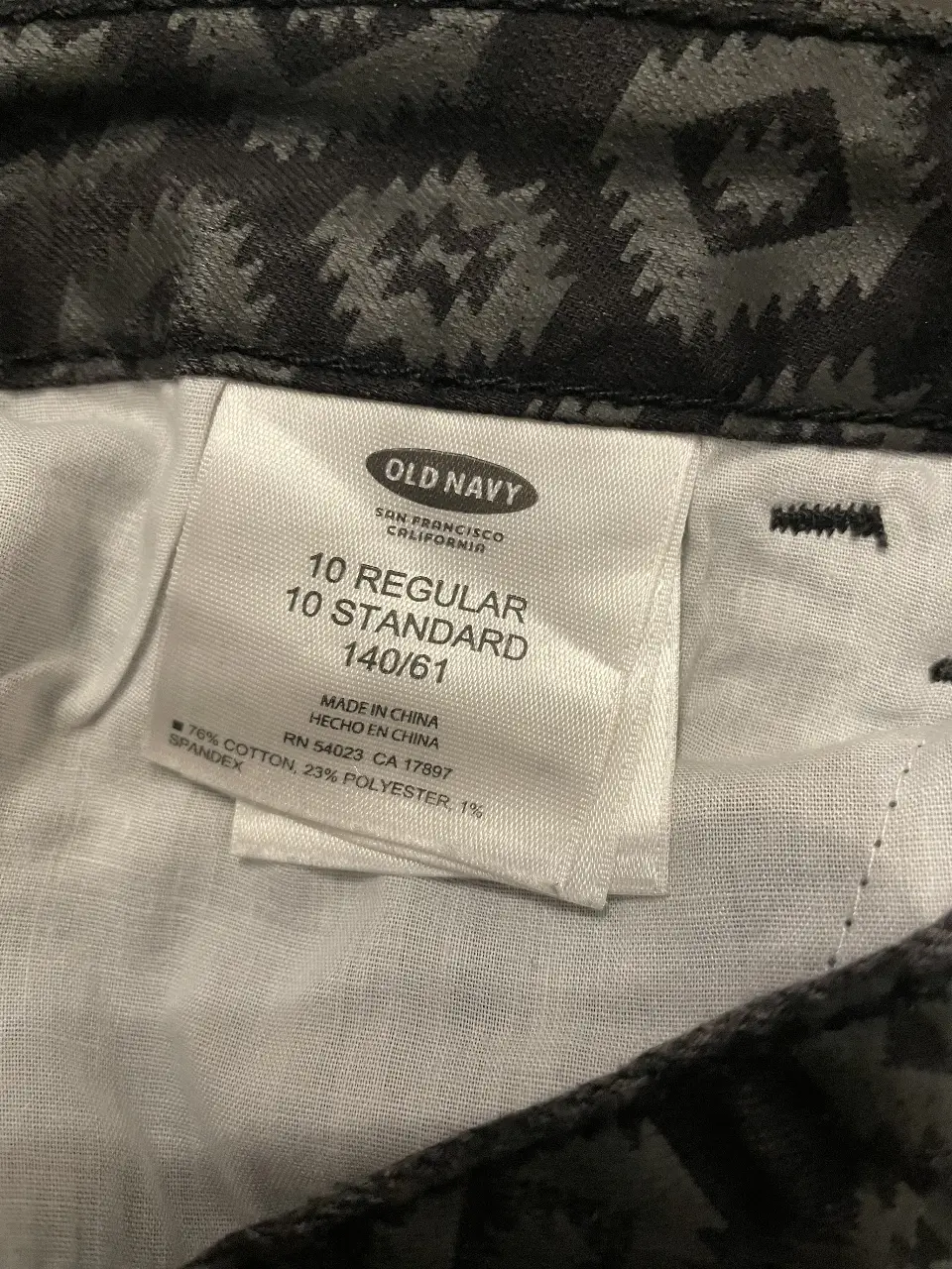 Pantalón de jean para niña, con estampado geométrico en tonos grises y negros. Talle 10 regular, de la marca Old Navy. Ideal para un look casual y cómodo.