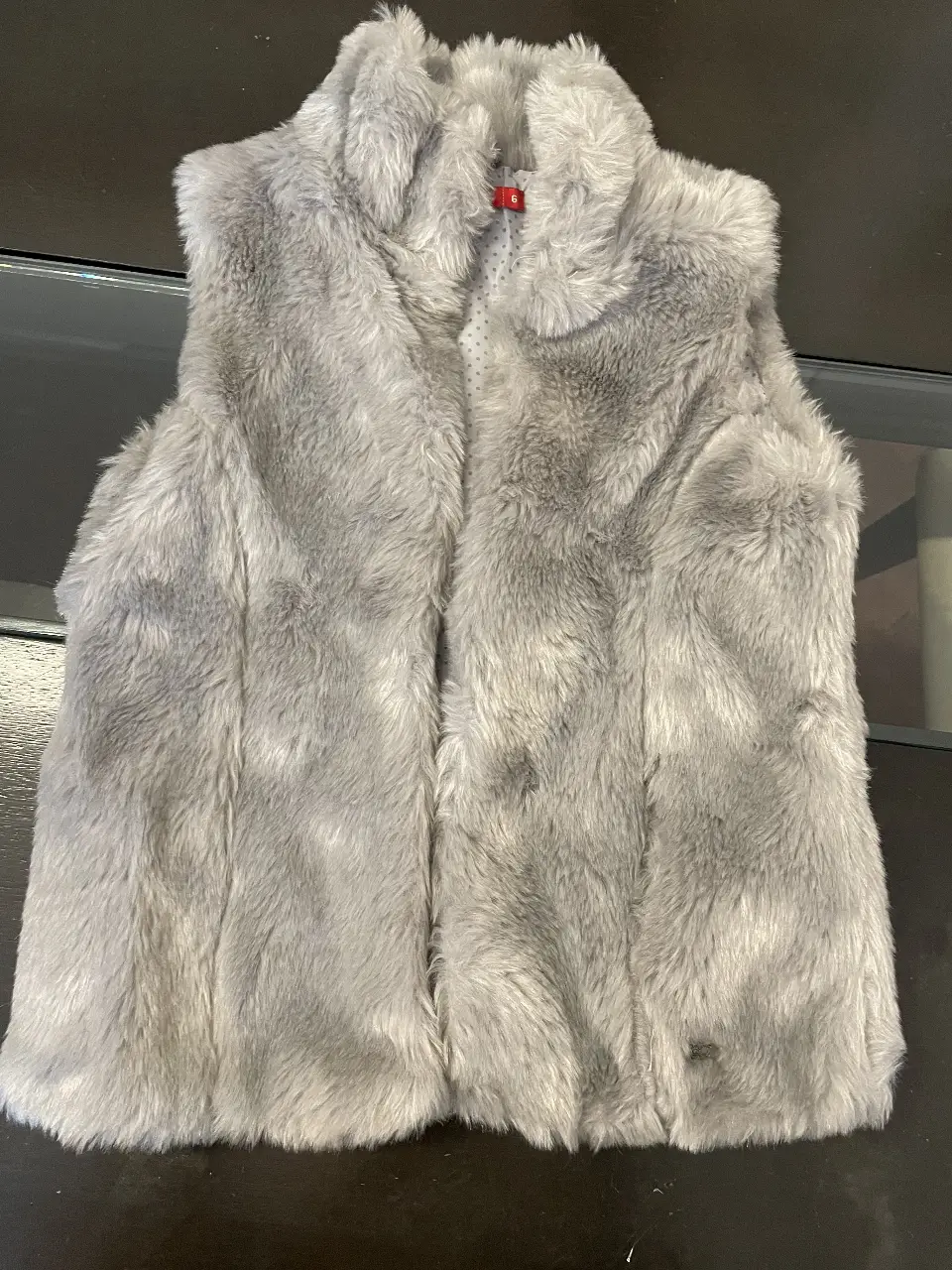 Chaleco de piel sintética gris para niña, con cuello alto y forro interior con estampado de lunares. Talle 6.