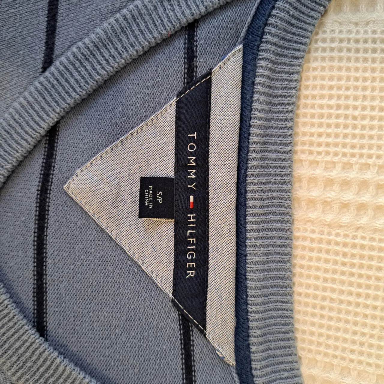 Sweater Tommy Hilfiger celeste con rayas negras, cuello en V y talle S. Ideal para un look casual y cómodo.