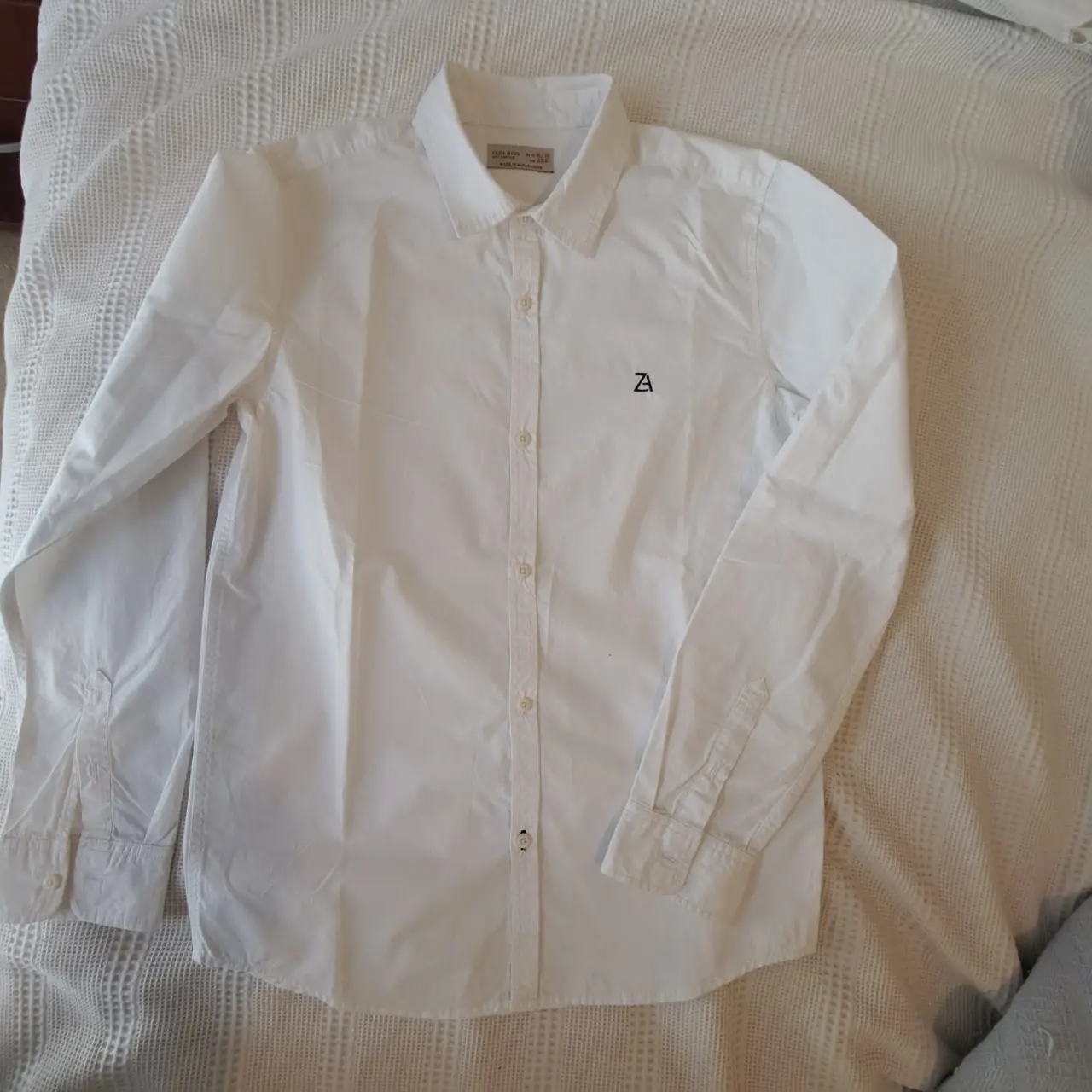 Camisa blanca de manga larga para niño, de la marca Zara Boys Collection. Talle 11/12, fabricada en Madagascar. Ideal para un look casual y cómodo.