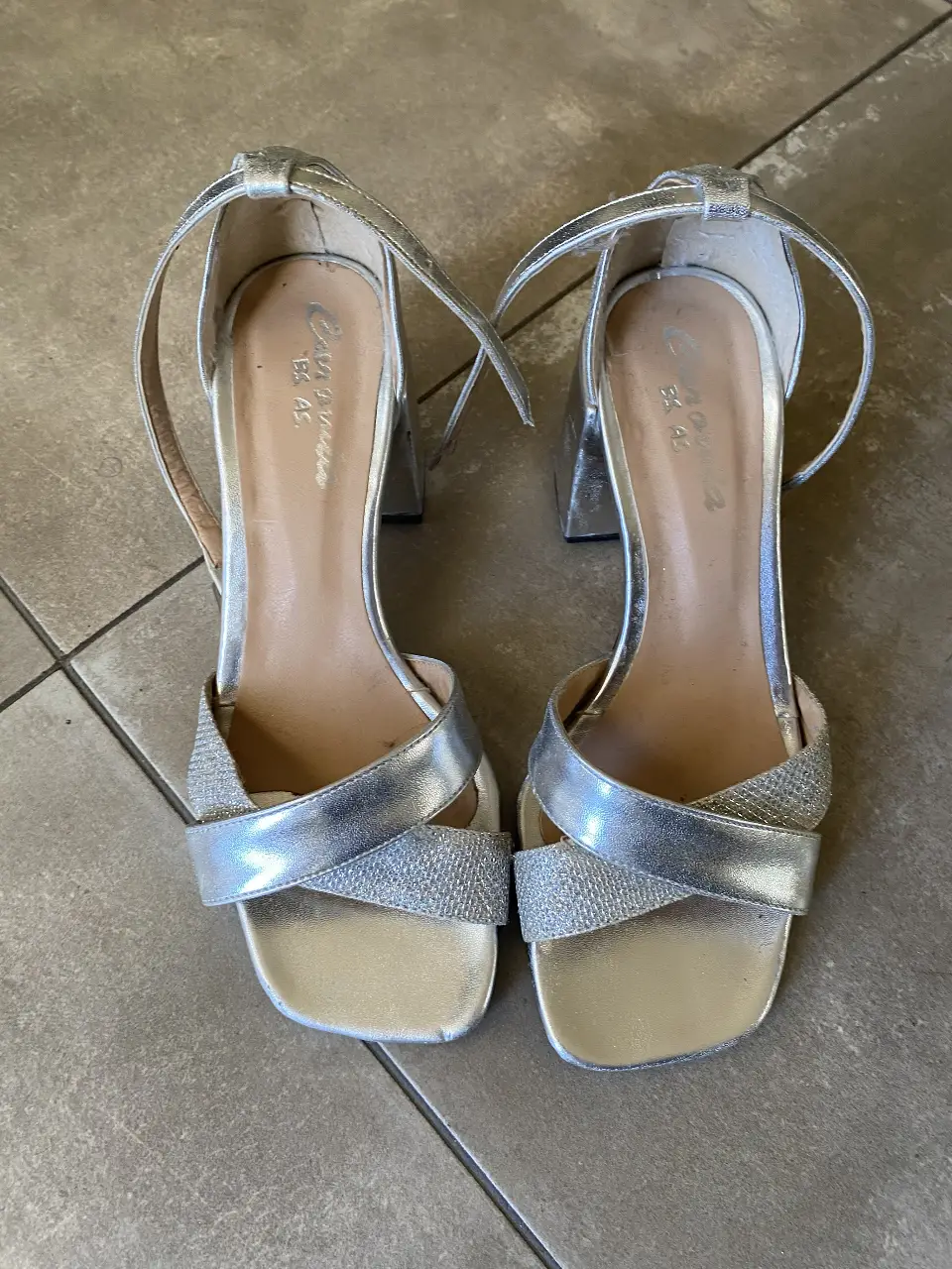 Sandalias plateadas de fiesta con taco cuadrado y tiras en el tobillo. Ideales para eventos y celebraciones.