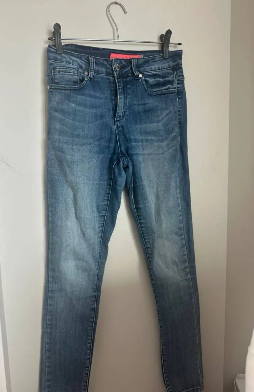 Jeans tiro medio/bajo, corte recto, con lavado desgastado y detalles de costura en contraste. Un básico infaltable para cualquier guardarropas.
