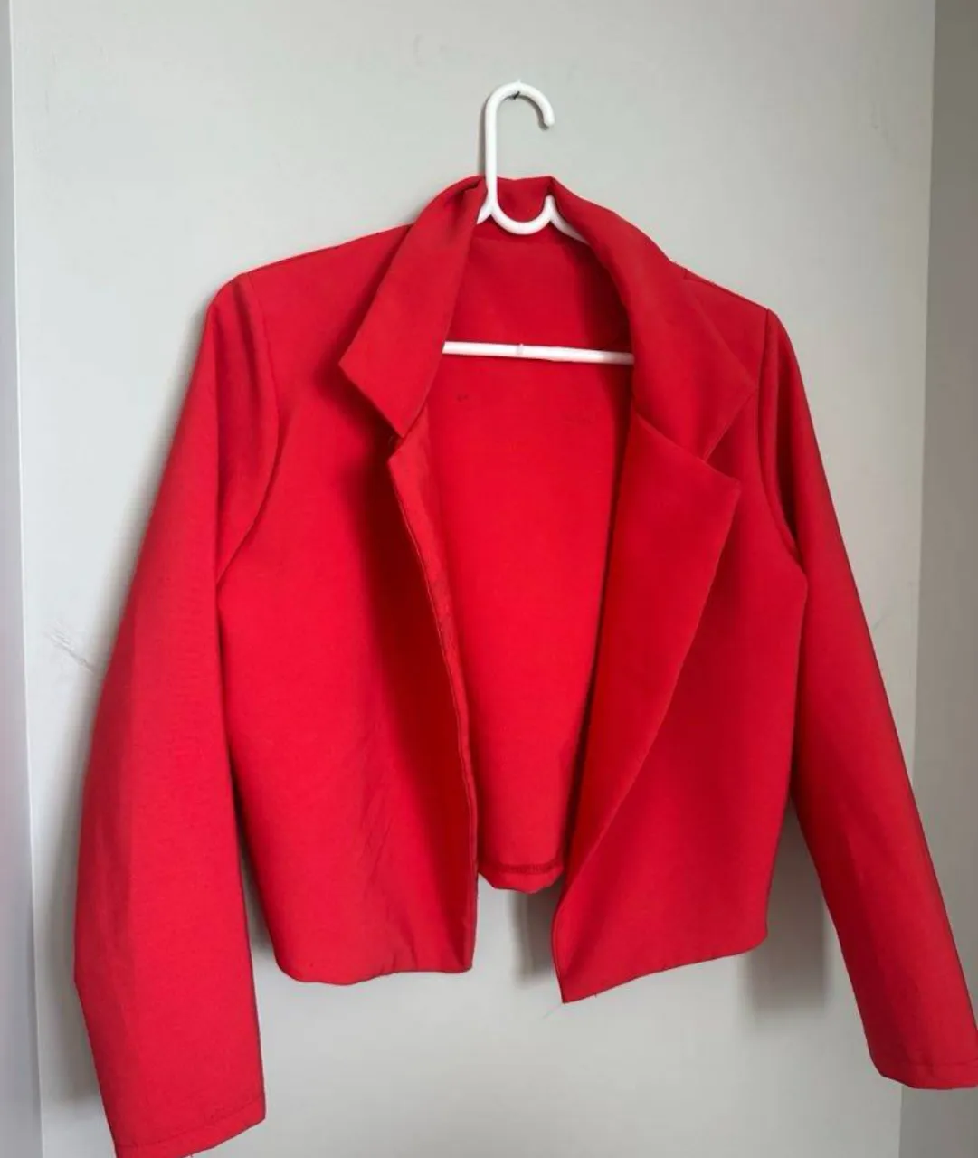 Blazer rojo corto, ideal para darle un toque de color y elegancia a cualquier outfit. Perfecto para usar en salidas o eventos.