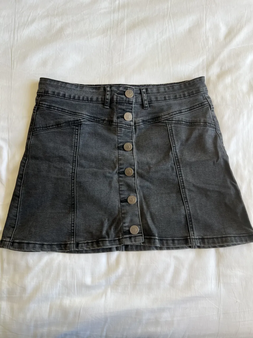 Pollera de jean gris/negra con botones al frente. Un básico súper canchero para armar looks divinos. Ideal para el día a día.