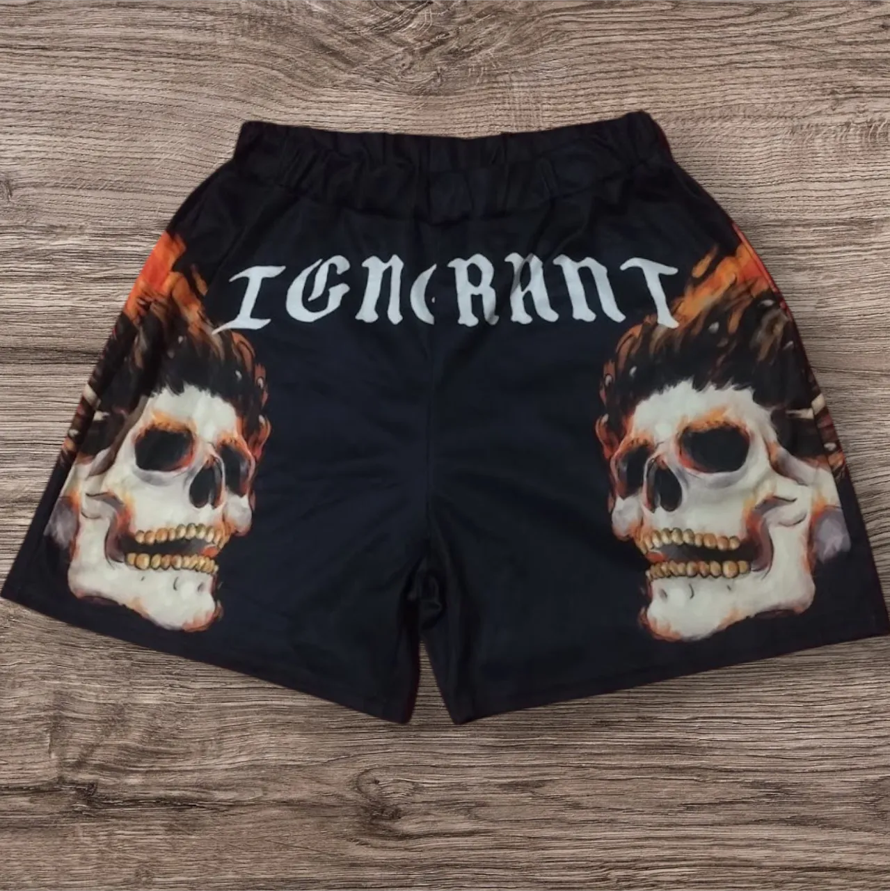 Shorts negros con estampa de calaveras y fuego a los costados. Detalle de la palabra "IGNORANT" en la parte superior. Ideales para un look urbano y canchero.