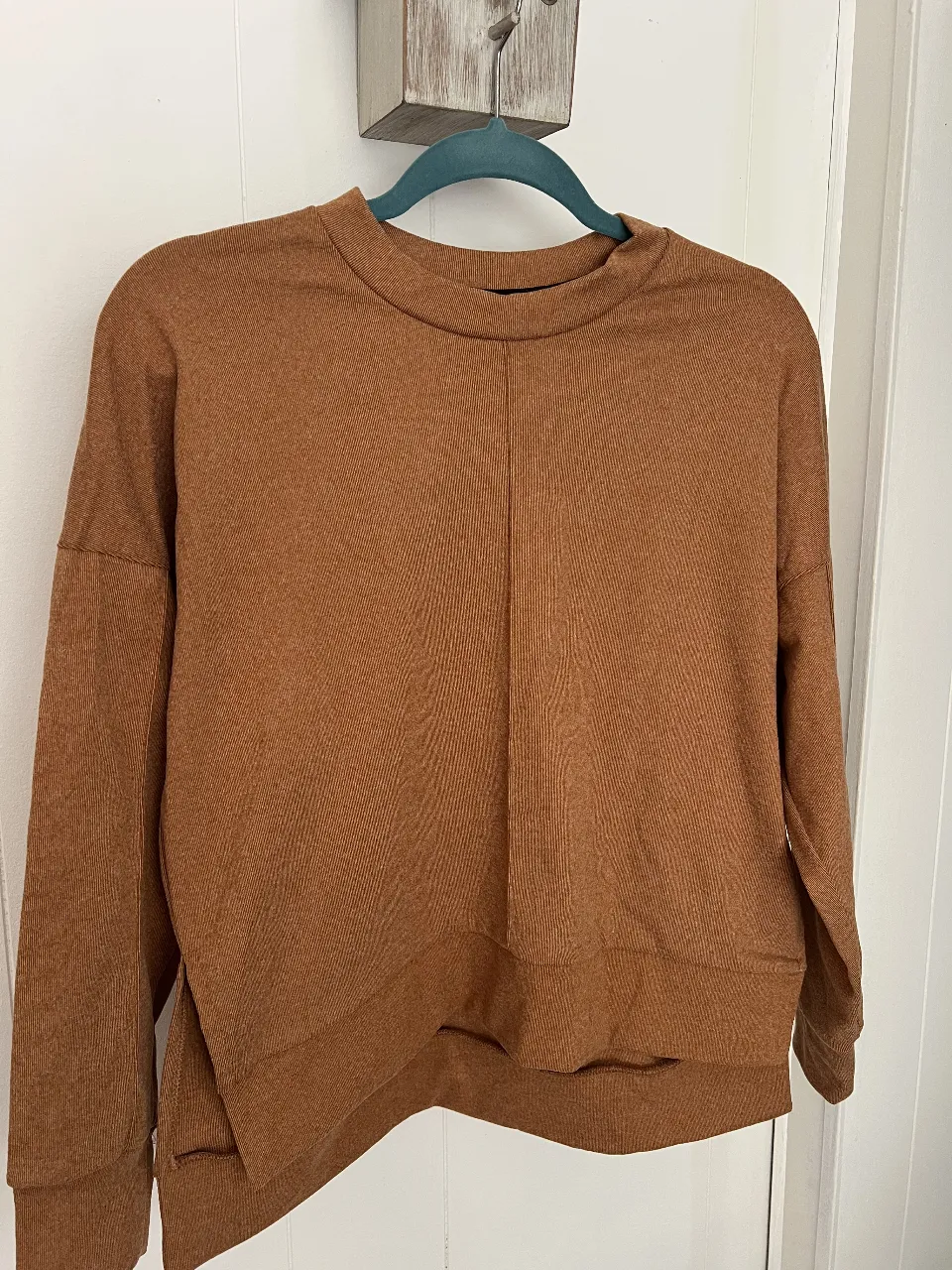 Buzo de cuello redondo para mujer, color marrón, de tela con textura acanalada. Ideal para un look casual y cómodo.