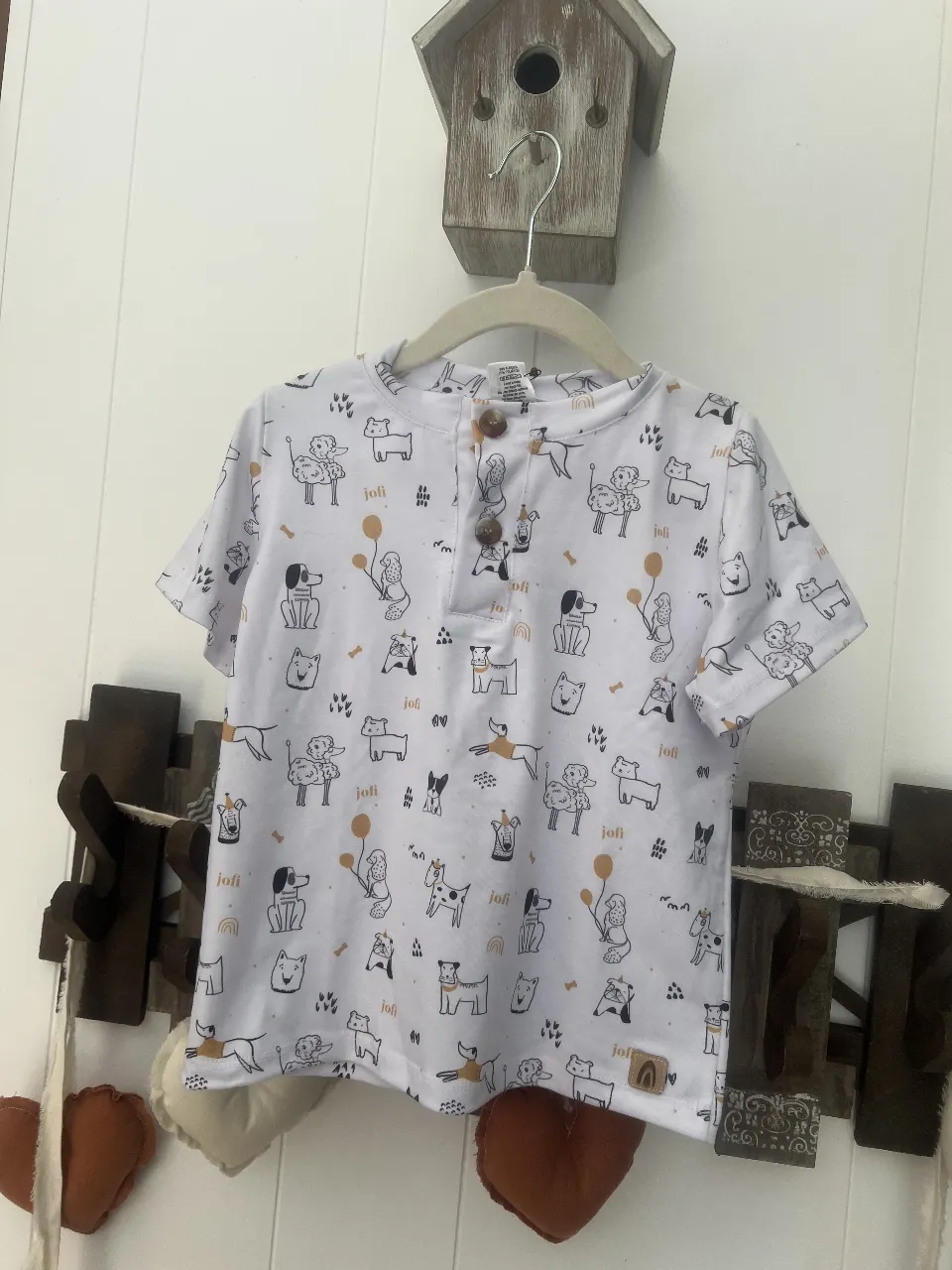 Remera de manga corta para niño, con estampado de perros y detalles dorados. Ideal para un look casual y divertido.