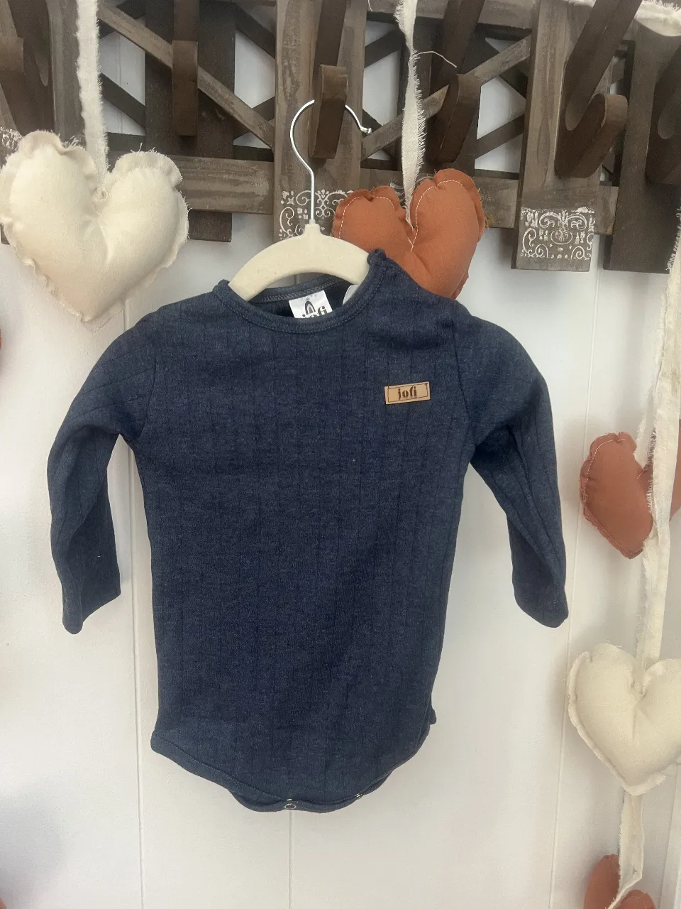 Body de manga larga azul marino para bebé, con detalle de etiqueta "jofi". Ideal para mantener a tu pequeño abrigado y cómodo.