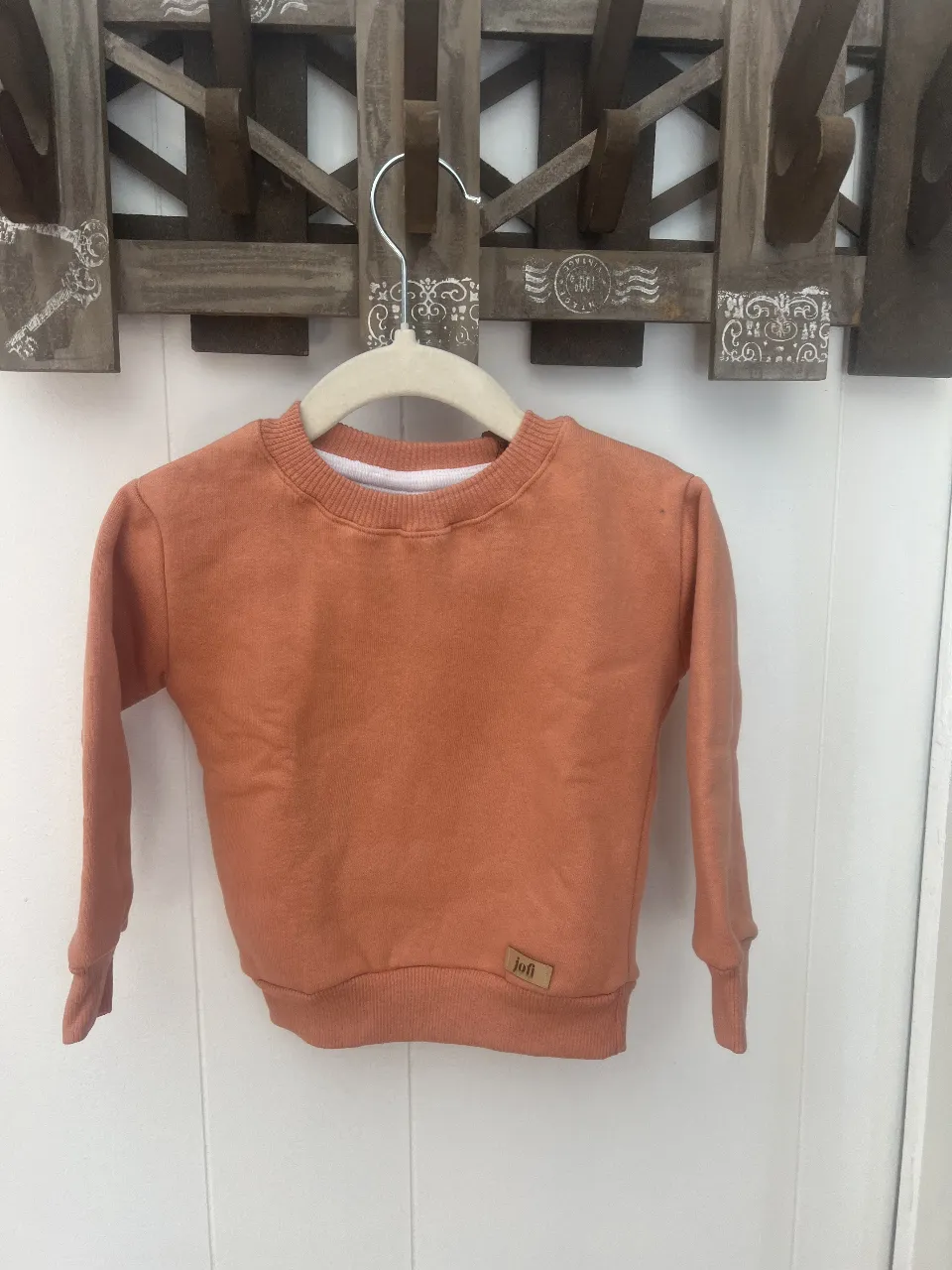 Buzo de cuello redondo color naranja para niños. Ideal para un look casual y cómodo.