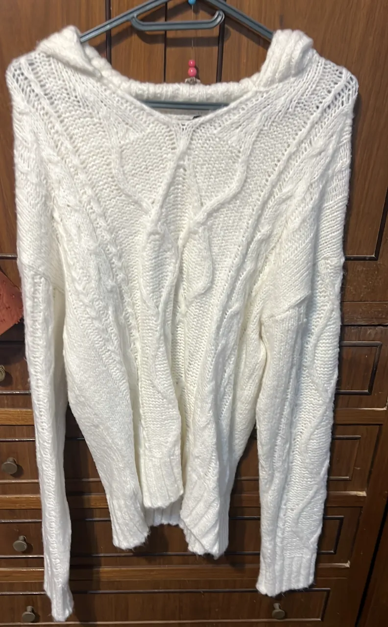 Sweater largo de mujer, tejido con capucha y diseño de trenzas. Ideal para un look casual y abrigado en invierno.