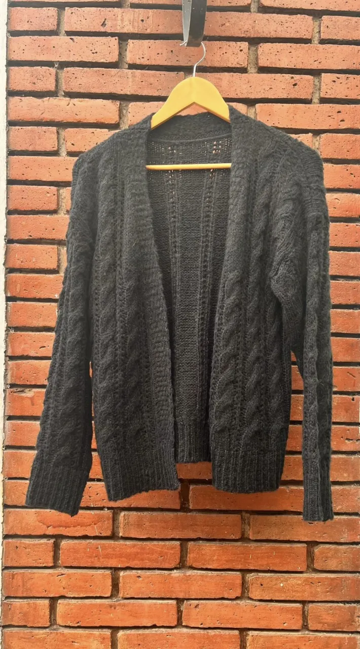 Cardigan de tejido grueso en color negro, con diseño de trenzas. Ideal para un look casual y abrigado.