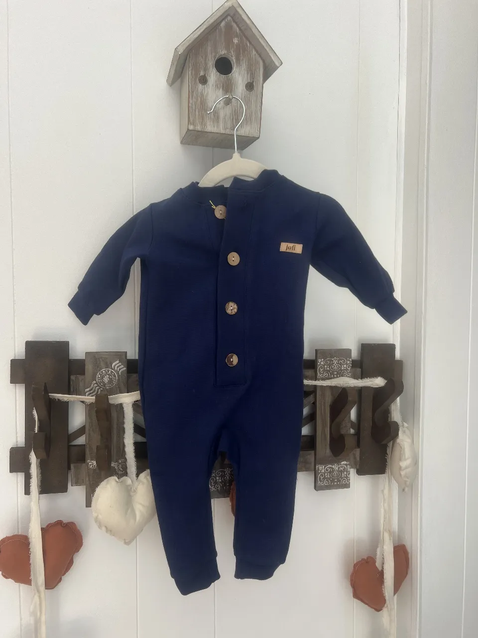 Body de bebé azul marino con botones de madera. Ideal para un look cómodo y moderno. Perfecto para el día a día.