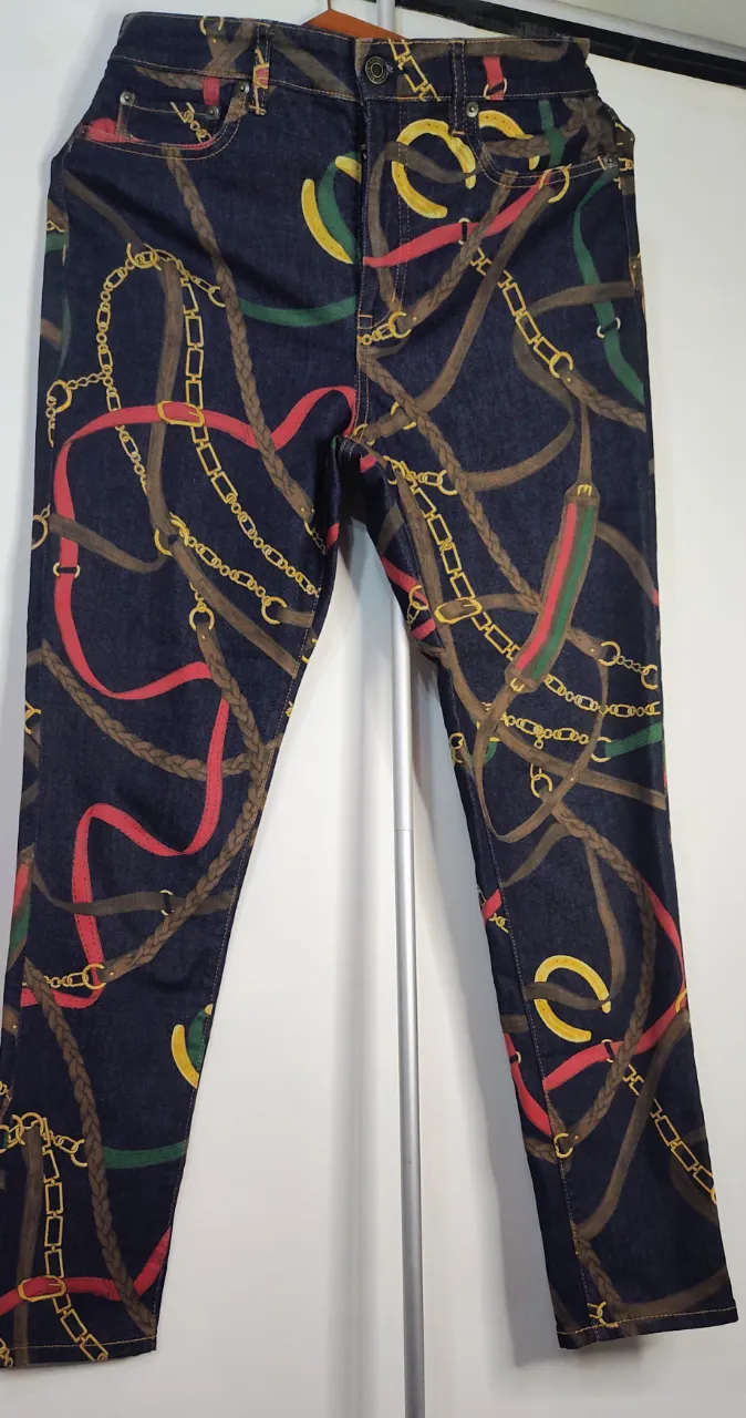 Super REBAJA 💥 Jeans de moldería clásica con estampa de cinturones y cadenas en tonos marrones, dorados, rojos y verdes. Cierre y botón. semi elástizado, tiro alto cintura 38 cm de lado a lado,  tiro 27 cm, 97 cm de largo.