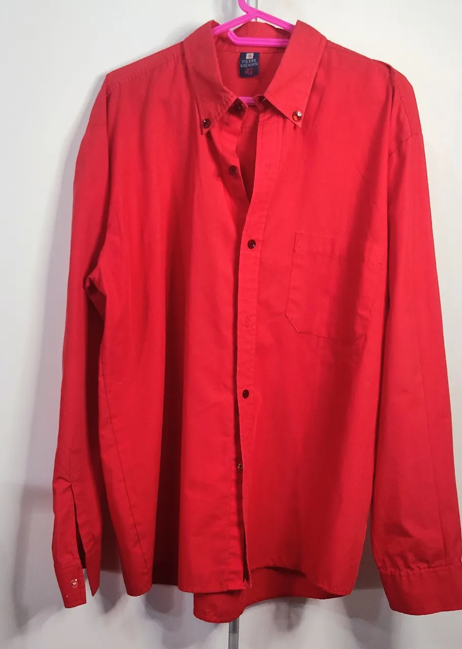 Camisa de manga larga de color rojo, con botones al frente y un bolsillo en el pecho, de sisa a sisa 60 cm de hombro 18 cm.
