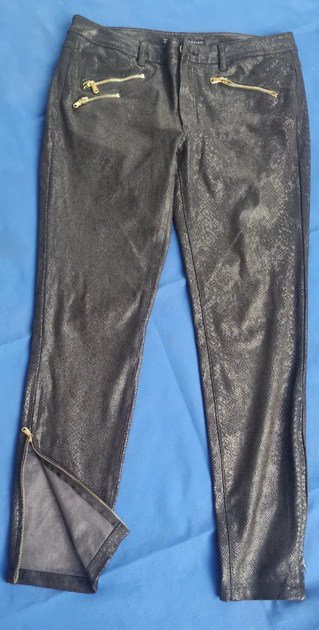 hermoso!!!Pantalón negro con textura de serpiente y detalles de cierres dorados. Un toque audaz y moderno para tu look.
