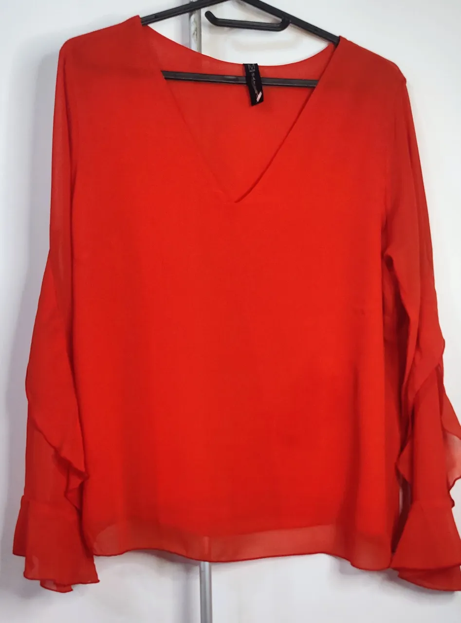 Presiosa 😍Blusa roja con escote en V y mangas largas con volados. La tela es liviana y tiene un acabado semitransparente, nueva. de sisa a sisa 52 cm.