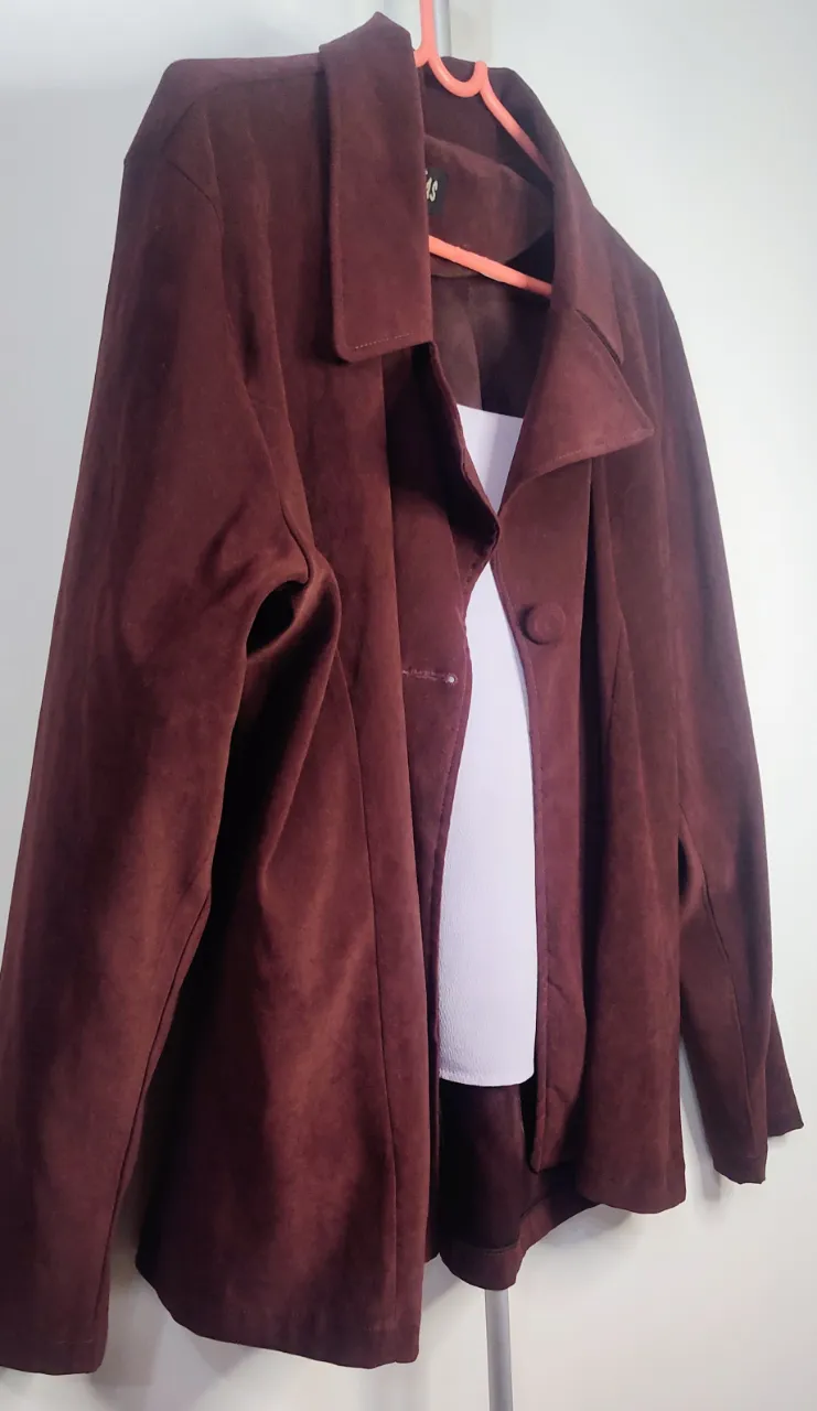 💥Saco o Blazer 💥de color bordó o vino tinto, confeccionado en un material suave  similar a la gamuza o paño fino. Presenta un diseño de corte clásico con solapas amplias, cierre frontal de botones y un ajuste ligeramente holgado u oversize.  de gamuza color bordo con un boton al frente y cuello solapa. de sisa a sisa 54 cm de hombro 14 cm.