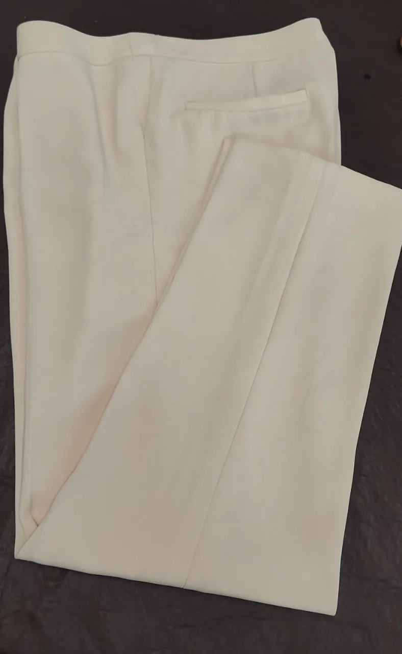 Pantalón Satrero de vestir corte formal en color crudo. Posee dos botones en la cintura y un cierre, bolsillos traseros; de cintura 40 cm de tiro 25 cm y de largo 94 cm. hermosa caída en su confección.