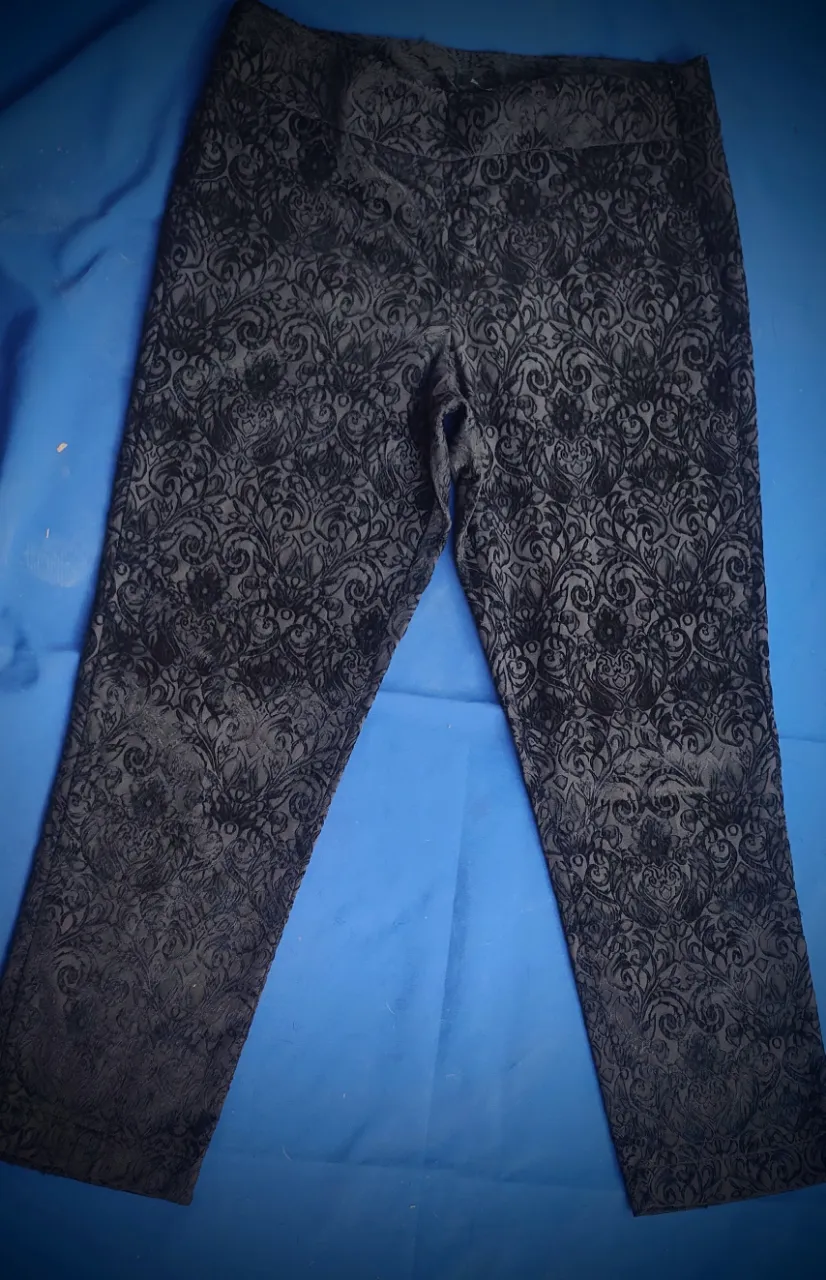 Pantalón de vestir con un estampado floral y ornamental en tonos oscuros. Diseño elegante y detallado, ideal para ocasiones especiales o para darle un toque sofisticado a tu look.
