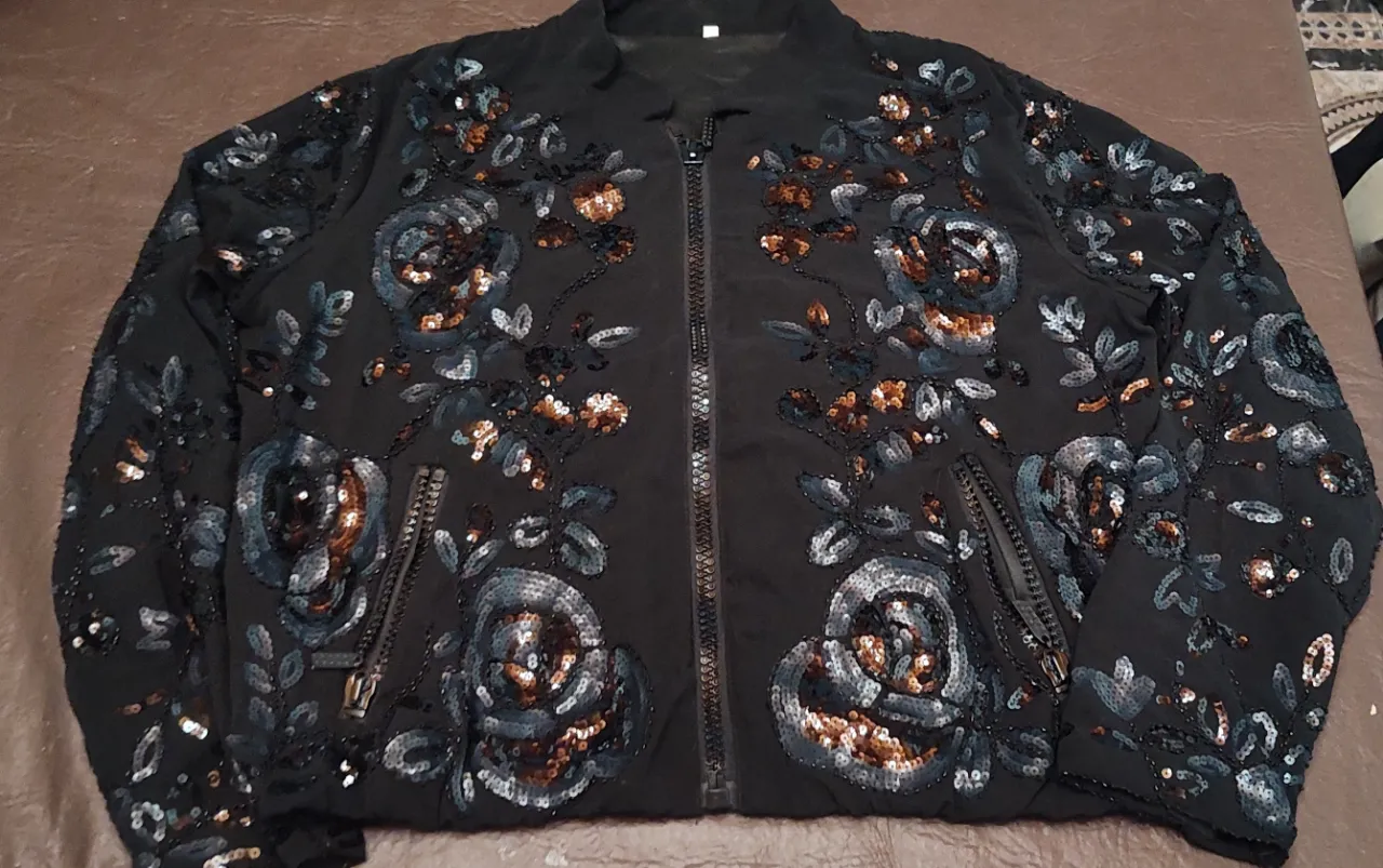 SÚPER REBAJA 💥 💥 💥 Eleva tu aufiis ❤️Campera bomber negra con bordados y lentejuelas de flores y hojas en tonos grises, marrones y plateados. Tiene cierre central y bolsillos con cierre. Hermosa de sisa a sisa 60 cm 13 cm de hombro y de largo 55 cm.

