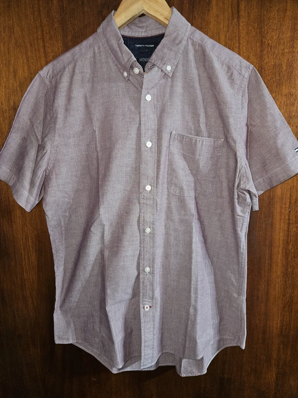 Camisa de vestir Tommy Hilfiger de manga corta, color bordó. Posee cuello tipo button-down y un bolsillo en el pecho. Ideal para un look casual o semi-formal.