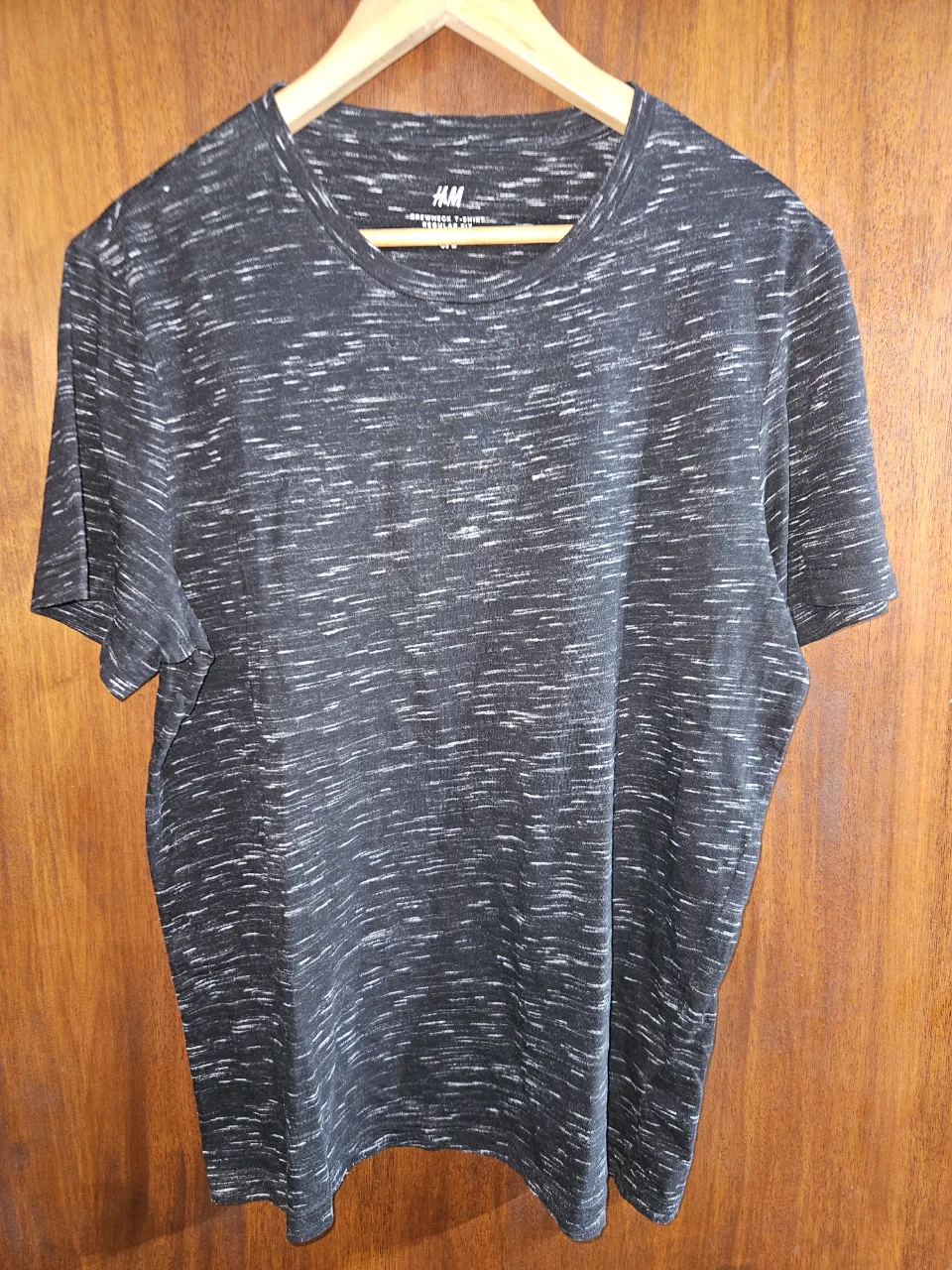 Remera negra jaspeada H&M con estampa de líneas finas blancas. Cuello redondo y manga corta. Ideal para el día a día.