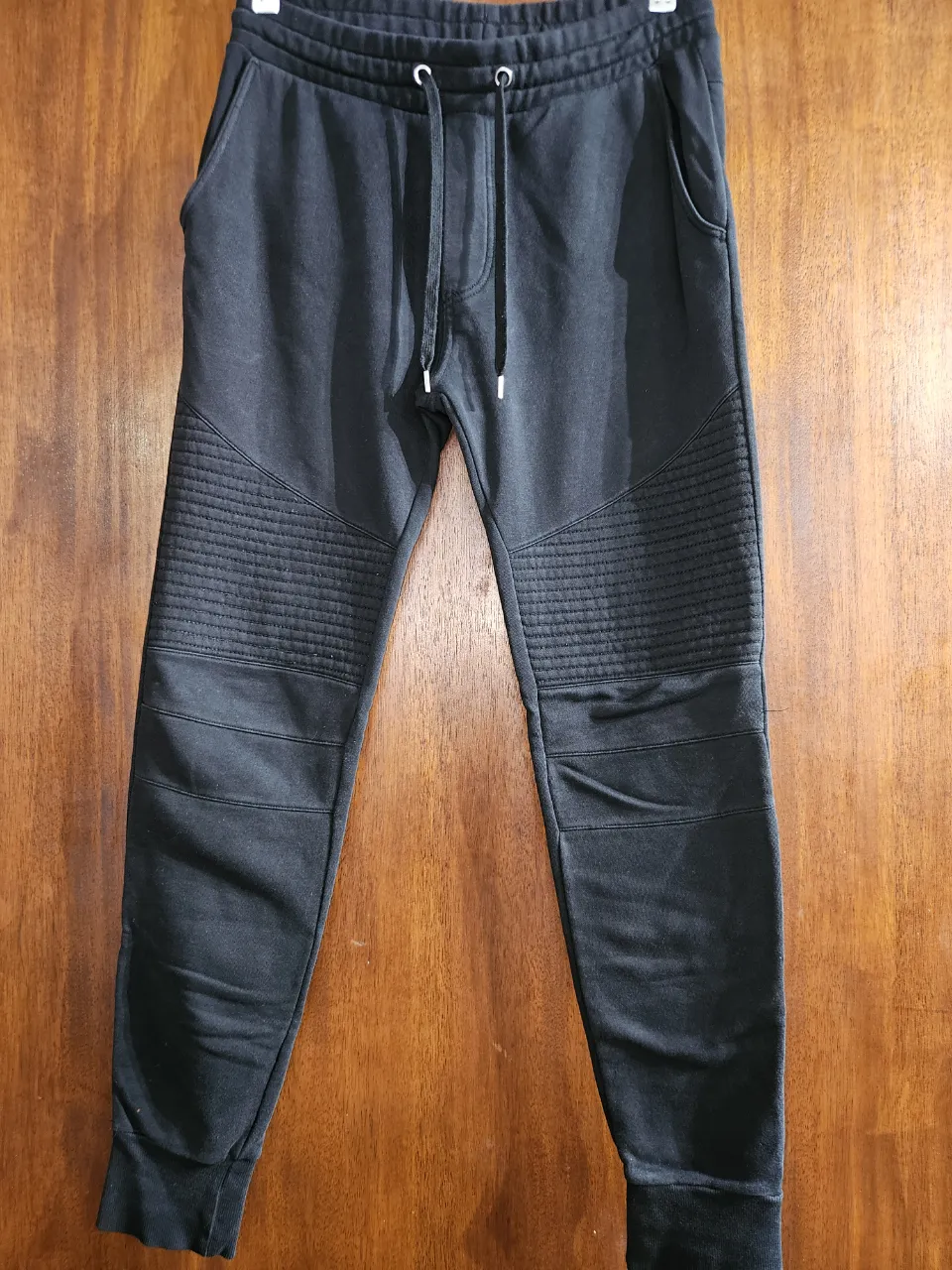Pantalon de jogging negro H&M. Cintura con cordón ajustable y bolsillos laterales y traseros. Ideal para un look urbano y cómodo.