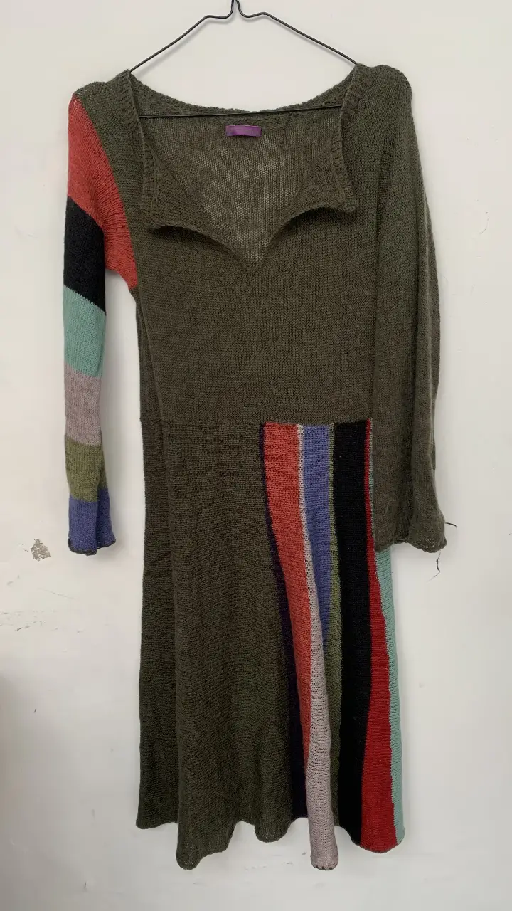 Vestido midi de lana con mangas largas y detalles multicolores en la manga y lateral. Estilo artesanal y cómodo, ideal para el invierno.