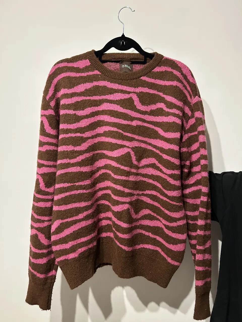 Sweater de mujer con estampado de cebra en tonos marrón y rosa. Cuello redondo y mangas largas. Ideal para un look casual y moderno.