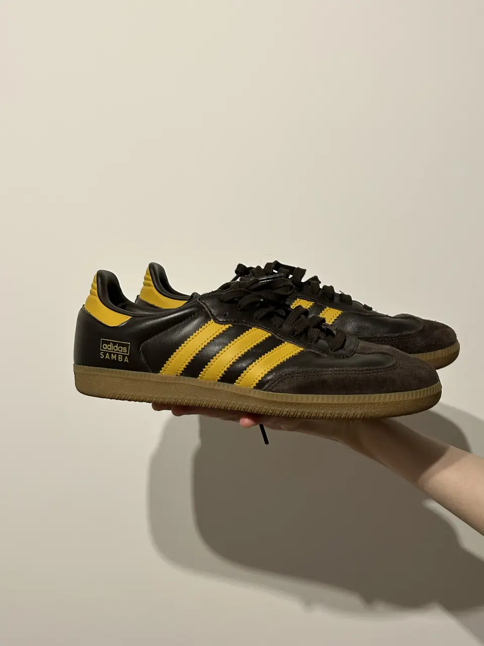 Zapatillas Adidas Samba en cuero marrón con detalles amarillos. Un clásico del calzado deportivo, ideal para un look casual y con estilo retro.