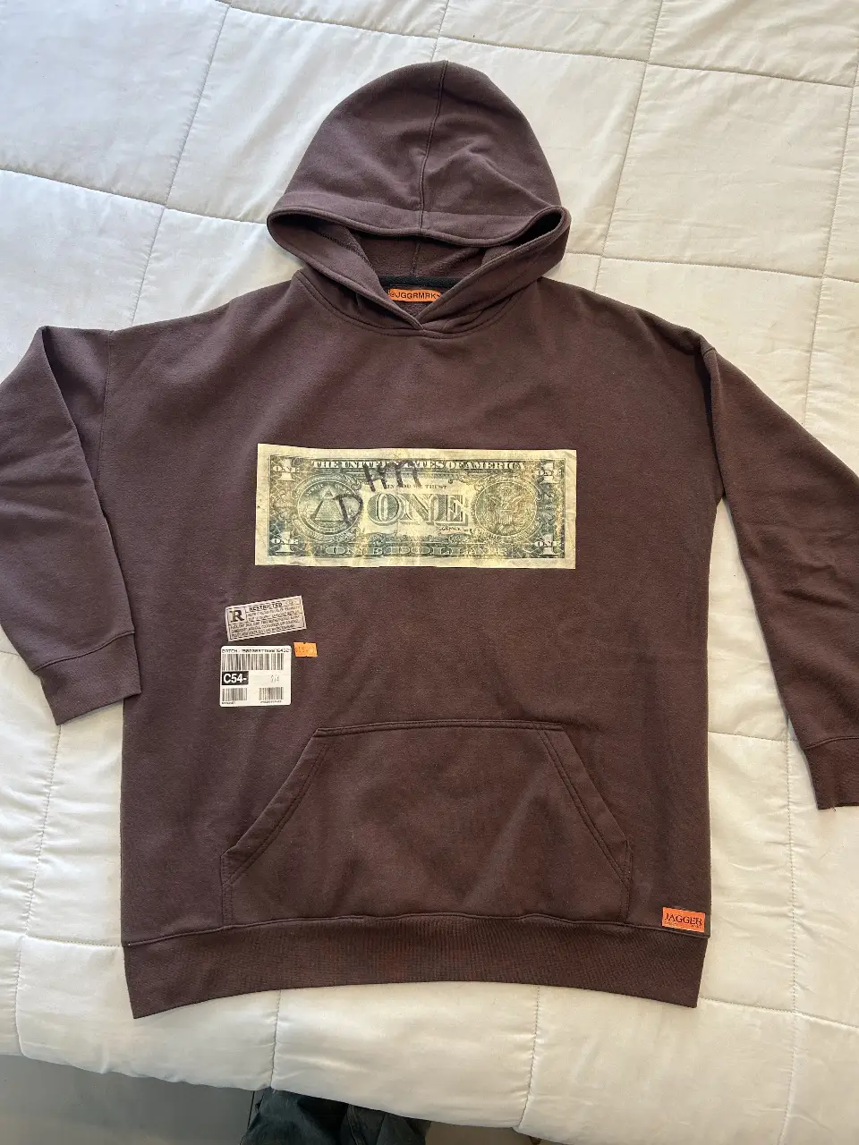 Buzo canguro marrón con estampado de billete de dólar en el frente. Estilo streetwear, ideal para un look casual y urbano.