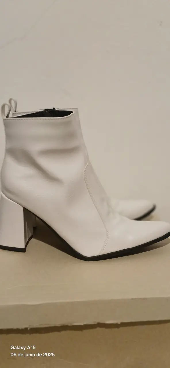 Botines blancos de cuero sintético con taco ancho y punta fina. Ideales para un look moderno y elegante.