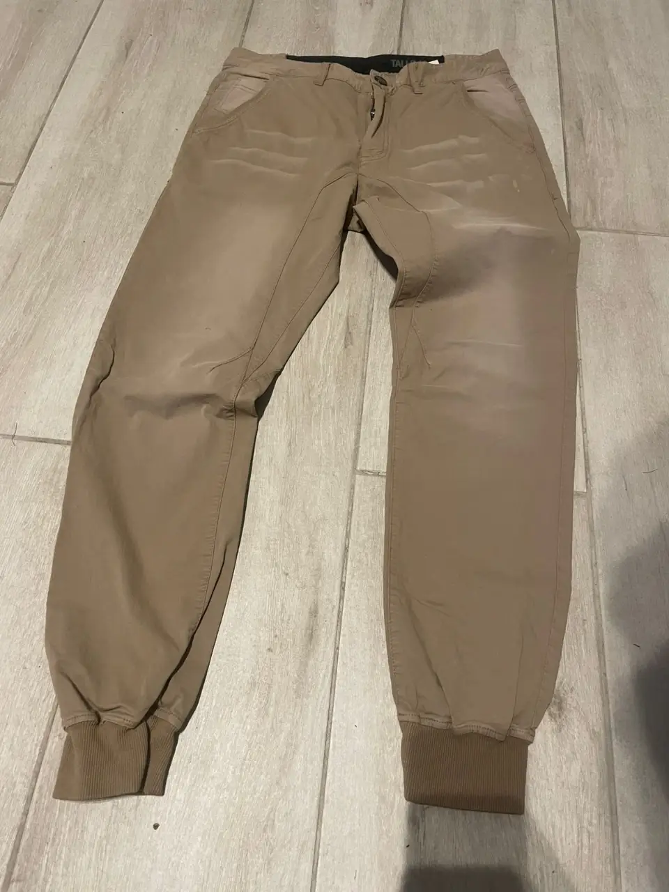 Pantalón cargo de hombre, color marrón, con puños en los tobillos. Ideal para un look casual y cómodo.