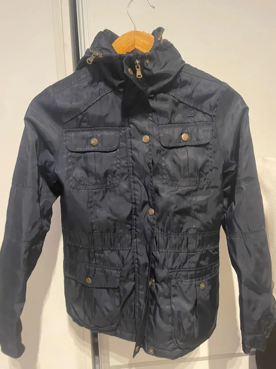 Campera azul oscura con capucha y múltiples bolsillos. Ideal para el día a día.