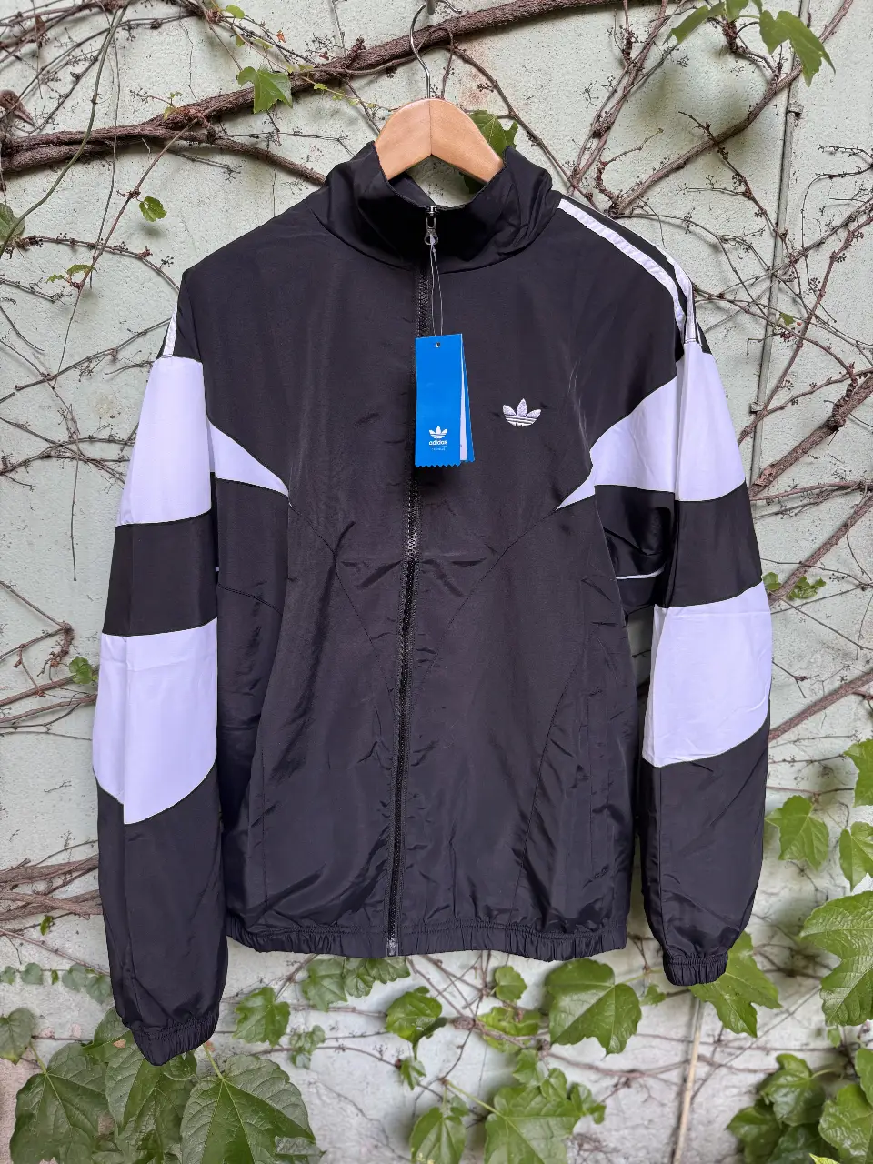 Campera deportiva Adidas negra con detalles blancos. Ideal para entrenar o usar en el día a día. Con cierre y logo de la marca. Replica triple A