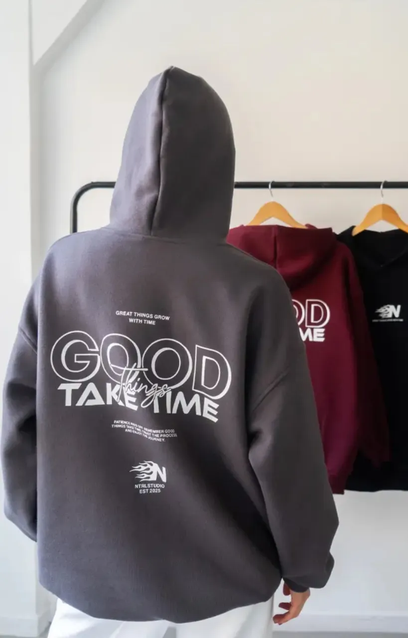 Buzo canguro oversize, color gris con estampado "GOOD TAKE TIME" en la espalda. Diseño urbano y cómodo, ideal para un look casual y moderno. Perfecto para el día a día.