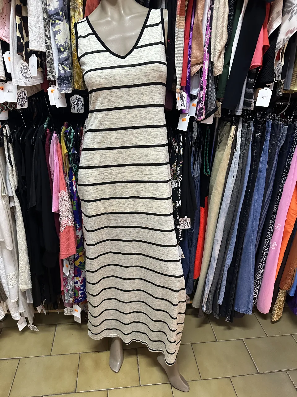 Vestido largo de mujer, con diseño a rayas horizontales en blanco y negro. Corte recto, sin mangas y escote en V. Ideal para un look fresco y moderno.