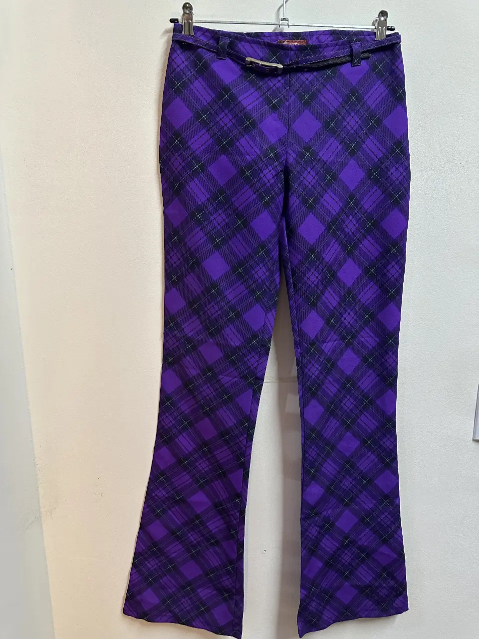 Pantalón sastrero de mujer con estampado a cuadros en tonos violeta y negro. Incluye cinturón a juego. Ideal para un look elegante y moderno.