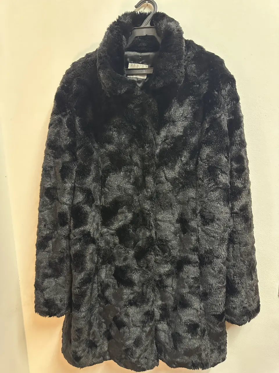 Tapado de piel sintética negro, largo, con cuello solapa y cierre de gancho. Ideal para un look elegante y abrigado.