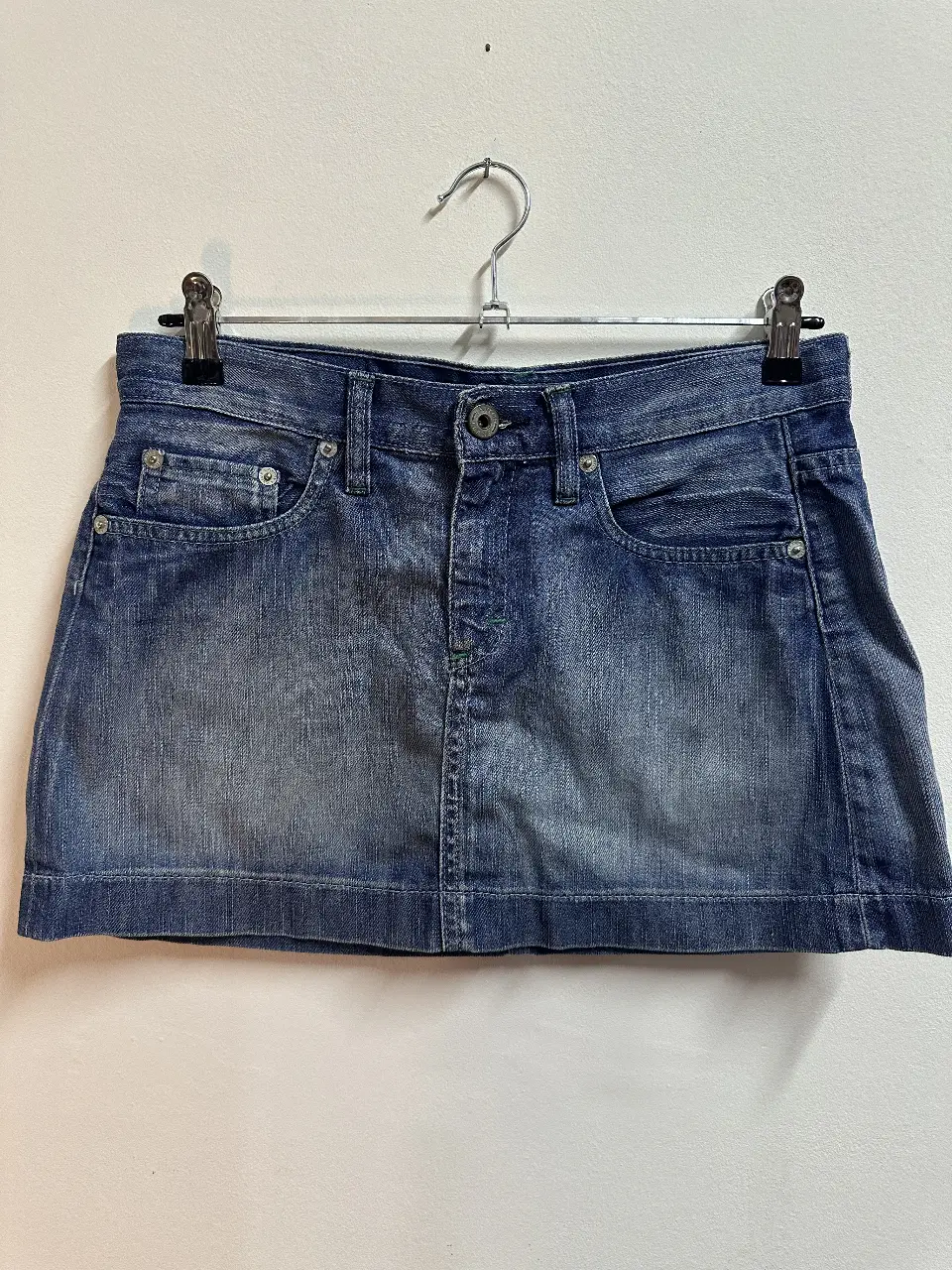 Minifalda de jean azul, con bolsillos delanteros y traseros. Ideal para un look casual y moderno.
