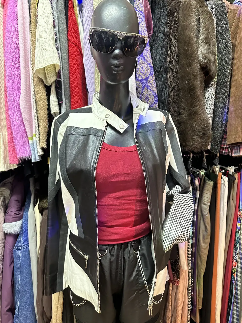 Campera biker de cuero sintético para mujer, con diseño a rayas en blanco y negro. Posee cierre frontal y detalles de cremalleras en los bolsillos. Ideal para un look rocker y moderno.
