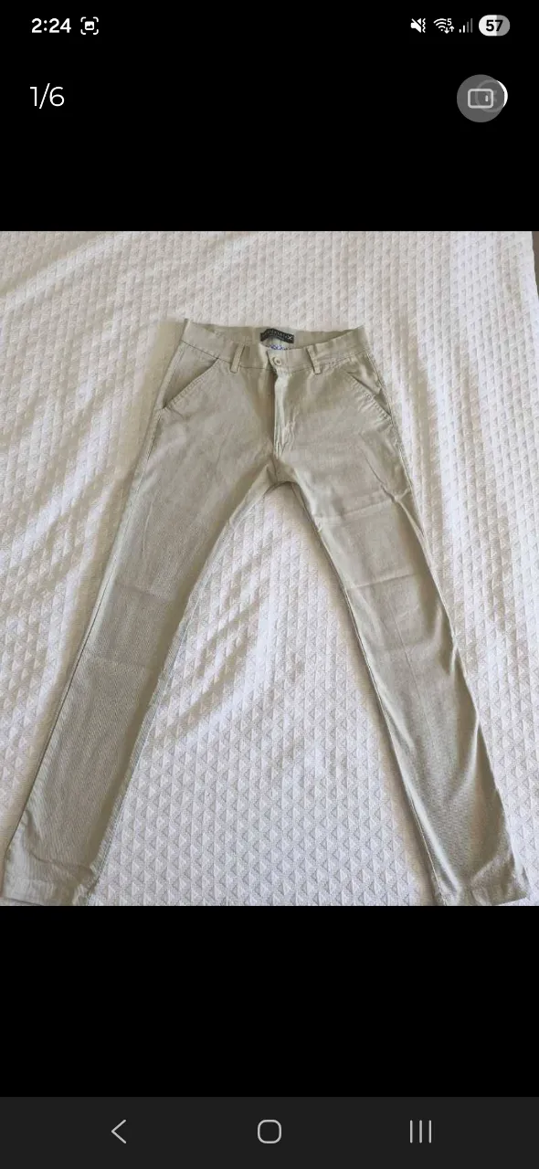 Pantalón de gabardina color crudo con finas rayas verticales. Posee bolsillos frontales y traseros.