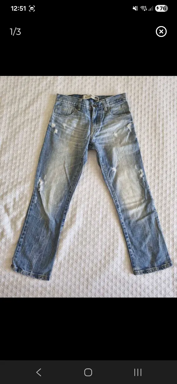 Jeans de corte clásico, con detalles de desgaste y roturas sutiles. Presentan un lavado claro que resalta las zonas de uso.
