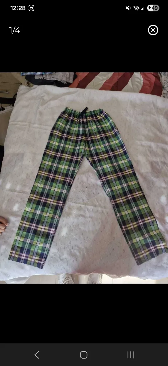 Pantalón de pijama a cuadros verdes, azules y blancos. Posee cordón de ajuste en la cintura y un bolsillo trasero con etiqueta.
